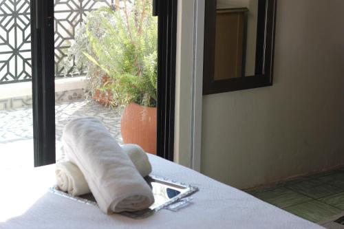 a rolled up towel sitting on a table next to a window at Casa Mestiza in Guadalajara
