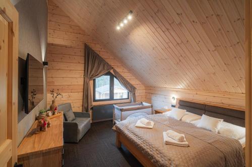 a bedroom with a large bed in a wooden room at Chatka u tatka in Vysoké Tatry