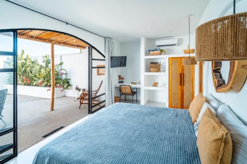 a bedroom with a bed and a room with a window at Las Guapas Villas Tamarindo in Tamarindo