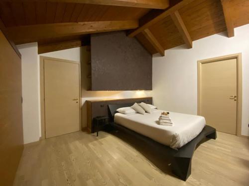 a bedroom with a bed with white sheets and wooden ceilings at Villa Fiesta in Oggiono