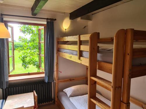 two bunk beds in a room with a window at Bauernhaus Sehestedt in Sehestedt