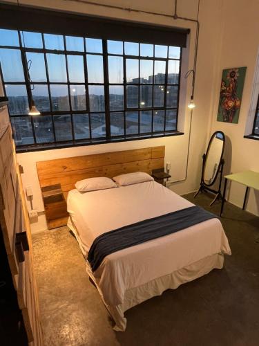 a bedroom with a bed and a large window at Lofty Hipster Penthouse in Johannesburg