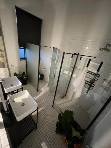 a bathroom with a sink and a shower and a toilet at Lofty Hipster Penthouse in Johannesburg