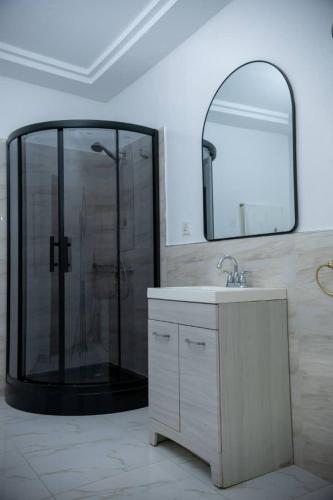 a bathroom with a shower with a sink and a mirror at Royal Galaxy Hotel in Kumasi