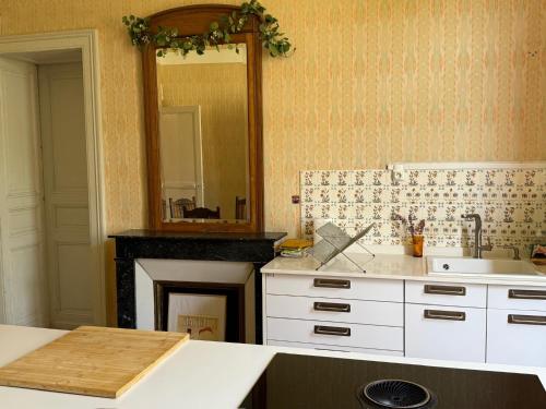 a kitchen with a fireplace and a sink and a mirror at Lingaillat in Soorts-Hossegor