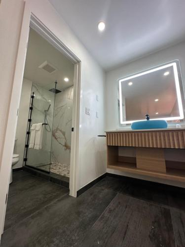 a bathroom with a shower and a sink and a mirror at Nubell Motel in Bell