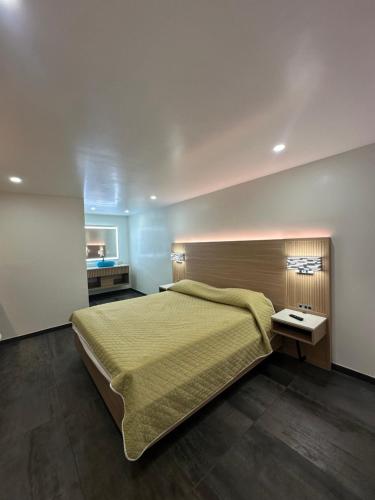 a bedroom with a large bed with a yellow bedspread at Nubell Motel in Bell