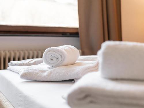 a pile of towels sitting on top of a bed at Brixen Alpin Living Top 18 in Brixen im Thale