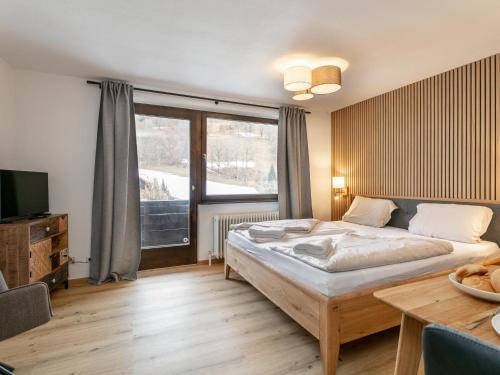 a bedroom with a bed and a large window at Brixen Alpin Living Top 19 in Brixen im Thale