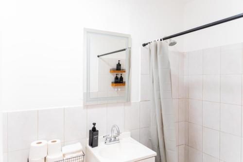 a white bathroom with a sink and a mirror at Spacious 2-Bedroom Apartment NYC-10 mins away in Union City
