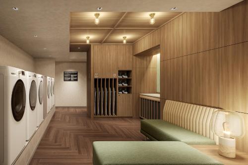 a dressing room with a green bench and wooden walls at Mitsui Garden Hotel Okayama in Okayama