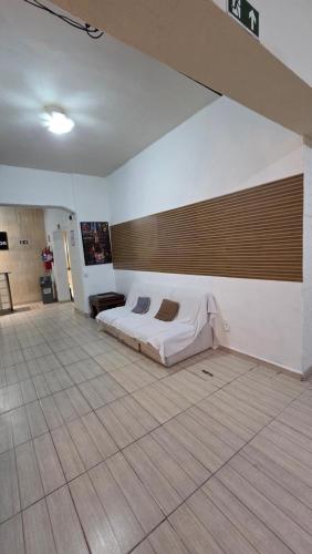 a bedroom with a bed in the middle of a room at Hotel Embaixador de Curitiba in Curitiba