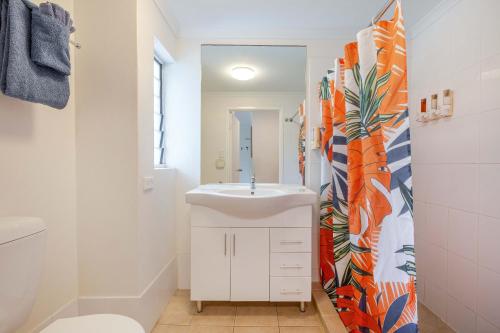 a bathroom with a white sink and a mirror at Port Douglas Motel in Port Douglas