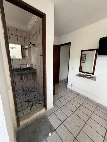 a bathroom with a shower and a mirror at Pousada do Nilo in Itapemirim