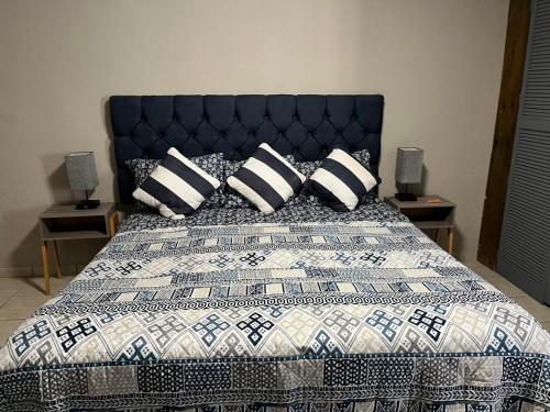 a bed with a blue and white quilt and pillows at Mirador de San Miguel in San Miguel de Allende