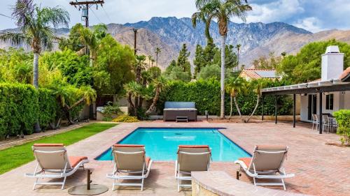 a swimming pool with chaise lounge chairs next to a house at Catalina by AvantStay Fully Remodeled Palm Springs Haven Pool Permit3432 in Palm Springs