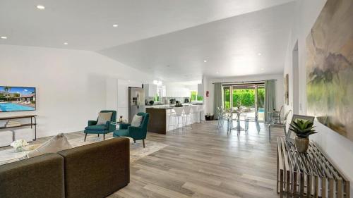 a living room with a couch and chairs and a kitchen at Catalina by AvantStay Fully Remodeled Palm Springs Haven Pool Permit3432 in Palm Springs
