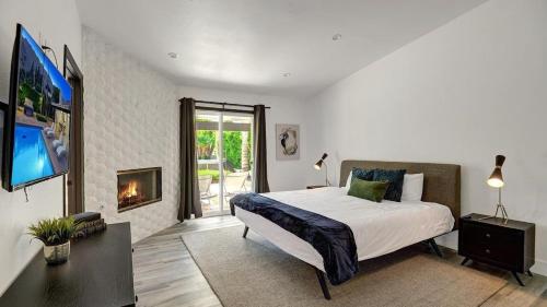 a bedroom with a large bed and a fireplace at Catalina by AvantStay Fully Remodeled Palm Springs Haven Pool Permit3432 in Palm Springs