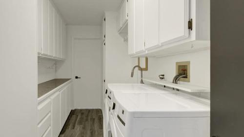 a white kitchen with white cabinets and sinks at Catalina by AvantStay Fully Remodeled Palm Springs Haven Pool Permit3432 in Palm Springs