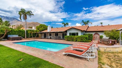 a house with a swimming pool and two lounge chairs at Catalina by AvantStay Fully Remodeled Palm Springs Haven Pool Permit3432 in Palm Springs