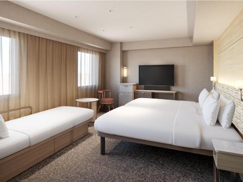 a hotel room with two beds and a television at Mitsui Garden Hotel Okayama in Okayama