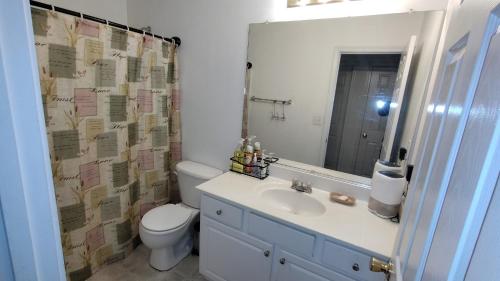 a bathroom with a sink and a toilet and a mirror at Kings Private Room Shared Bath C in Decatur