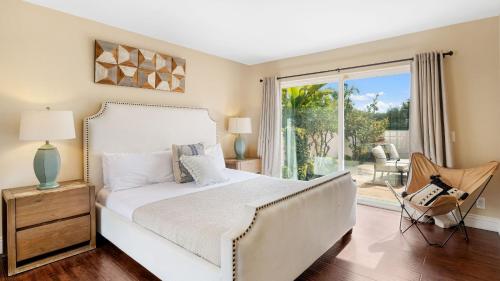 a bedroom with a white bed and a sliding glass door at Grapevine by AvantStay Secluded 5BR Villa 4 Acres of Vineyards Avo Groves in Temecula