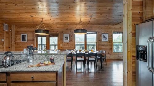 a kitchen with a dining room with a table at Hickory Ridge by AvantStay Sleeps 20 Incredible Private Elevated Cabin in Gatlinburg