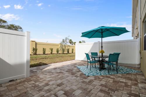 a table and chairs with an umbrella on a patio at Four Bedrooms TownHome 5161 in Kissimmee