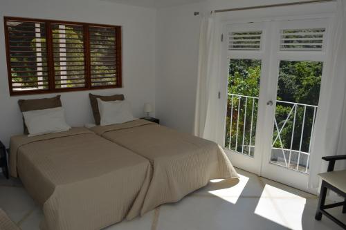a bedroom with a bed and a large window at Villa Noria in Las Terrenas