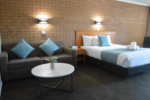 a hotel room with a bed and a couch at James Street Motor Inn in Toowoomba