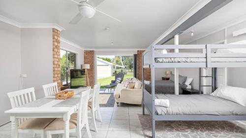 a bedroom with a bunk bed and a dining room at Port View on the Peninsula in Lemon Tree Passage