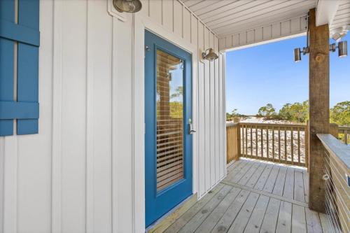 a house with a blue door on a deck at High Point Hideaway on the Sand Dunes - Unit 2 in Dauphin Island