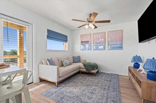 a living room with a couch and a ceiling fan at High Point Hideaway on the Sand Dunes - Unit 3 in Dauphin Island