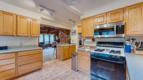 a kitchen with wooden cabinets and stainless steel appliances at Riversong Lodge by AvantStay Sauna Hot Tub On The Truckee River in Truckee
