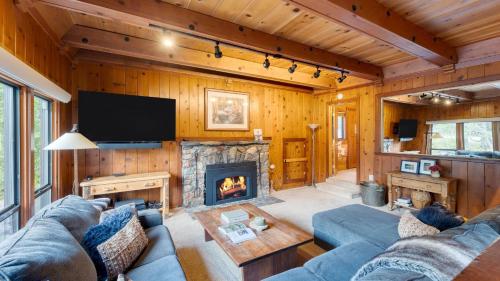 a living room with a couch and a fireplace at Riversong Lodge by AvantStay Sauna Hot Tub On The Truckee River in Truckee