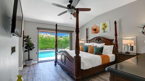a bedroom with a bed with a ceiling fan and a window at Ranch Oasis w Private Pool HotTub Firepit Mountain Views Gobi by AvantStay in Palm Springs
