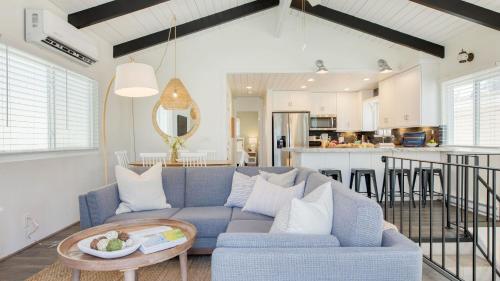a living room with a blue couch and a kitchen at Surfrider II by AvantStay Walk to the Beach Balcony in Newport Beach