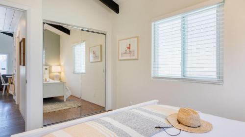 a bedroom with a bed with a hat on it at Surfrider II by AvantStay Walk to the Beach Balcony in Newport Beach
