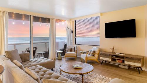 a living room with a couch and a flat screen tv at Beachfront Home w Ocean Views • Right on Mission Beach Belmont by AvantStay in San Diego