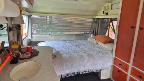 a small bedroom with a bed in a tiny house at Boutique Retro Caravan in Westport