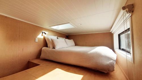 a small bedroom with a bed and a window at The Tiny Diamond in Diamond Harbour