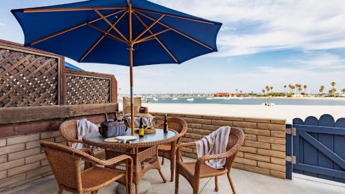 a table and chairs with an umbrella on the beach at Bay View II by AvantStay Ocean View Mission Beach Home on the Sand in San Diego