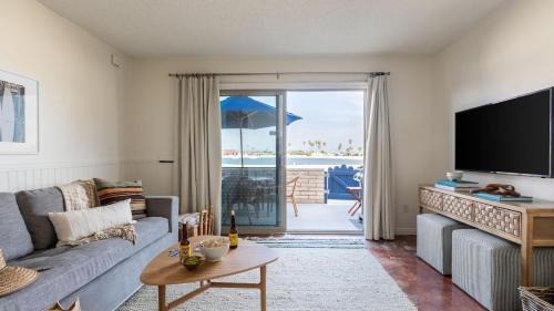 a living room with a couch and a tv at Bay View II by AvantStay Ocean View Mission Beach Home on the Sand in San Diego