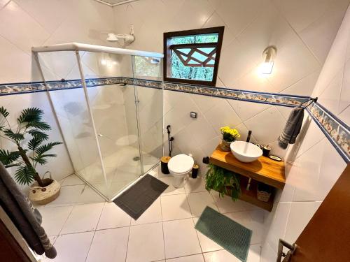 a bathroom with a shower and a toilet and a sink at Pousada Nalu - Camburi in Camburi