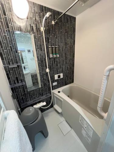 a bathroom with a tub and a toilet and a sink at One Point Five in Tokyo