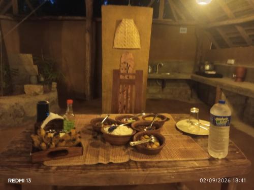 un tavolo di legno con sopra delle ciotole di cibo di Sun & Queen Villa a Dambulla