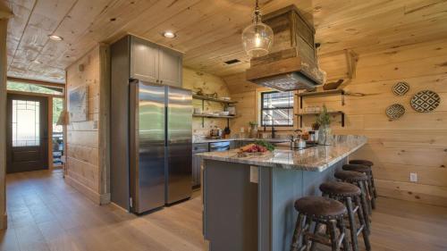 a kitchen with a stainless steel refrigerator and wooden walls at Birch Lodge by AvantStay Indoor Pool Theater Game Room Stunning Views in Gatlinburg