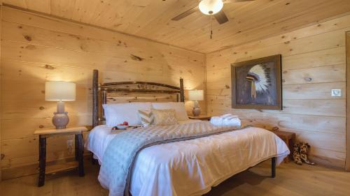 a bedroom with a bed in a log cabin at Birch Lodge by AvantStay Indoor Pool Theater Game Room Stunning Views in Gatlinburg