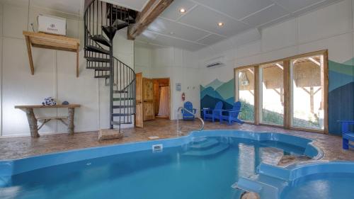 a large swimming pool in a room with a staircase at Birch Lodge by AvantStay Indoor Pool Theater Game Room Stunning Views in Gatlinburg